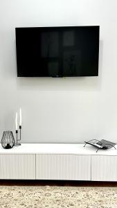 a flat screen tv hanging on a white wall at Yourhome - #105 Комфорт сити in Almaty