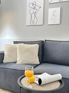 un vaso de zumo de naranja en una mesa junto a un sofá en Yourhome - #105 Комфорт сити, en Almaty