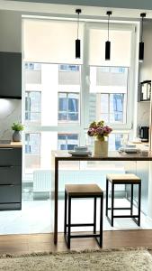 a kitchen with a table and two stools at Yourhome - #105 Комфорт сити in Almaty