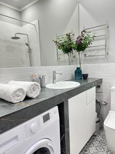 a bathroom with a washing machine and a sink at Yourhome - #105 Комфорт сити in Almaty