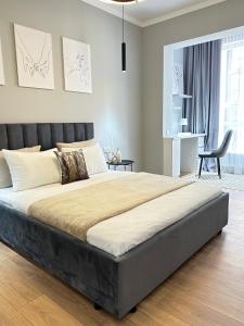 a bedroom with a large bed and a chair at Yourhome - #105 Комфорт сити in Almaty