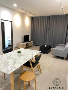 a living room with a table and chairs and a couch at Kuching Cozy Balinese Style Rex Apartment Near BDC in Kuching