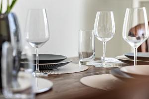 a wooden table with wine glasses and plates on it at Apartment Alb Glück 1 in Hechingen