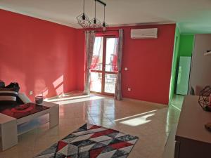 Tindaya Apartments في أهيلوي: غرفة معيشة بجدران حمراء وأريكة