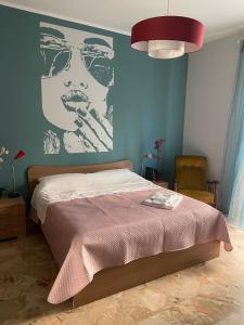 una camera da letto con un letto e un dipinto di una donna con occhiali da sole di I Giardini di Villa Giulia a Palermo