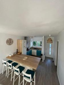 Una cocina y un comedor con mesa y sillas de madera. en Appartement 4 personnes Mimizan, en Mimizan