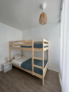 Litera en habitación con pared blanca en Appartement 4 personnes Mimizan, en Mimizan 12 fotos más