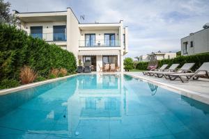 a swimming pool in front of a house at Vila 29 Valamar in Durrës