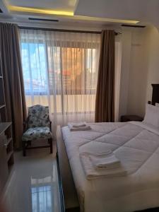 een slaapkamer met een bed, een stoel en een raam bij The Sailors Address in Thika