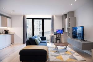 a living room with a blue couch and a table at Spacious & Smart Studio Flat with Balcony - Zone1 in London