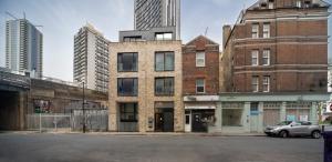 an old brick building on a street with tall buildings at Spacious & Smart Studio Flat with Balcony - Zone1 in London