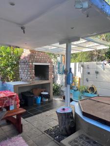 a patio with a brick fireplace and an umbrella at Bougain Villa Self-catering ,Darling in Darling