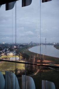 uma vista para um rio a partir da janela de um edifício em The Zipper Hotel und Apartments em Dusseldorf