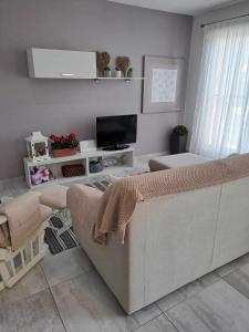 ein Wohnzimmer mit einem Sofa und einem TV in der Unterkunft 74 temple point 3 bedroom APT in Marsaxlokk