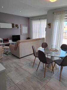 ein Wohnzimmer mit einem Sofa, einem Tisch und Stühlen in der Unterkunft 74 temple point 3 bedroom APT in Marsaxlokk