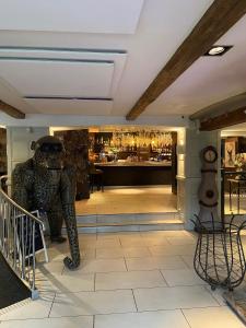 a statue in a lobby with a bar in the background at The White Hart Hotel in Uttoxeter