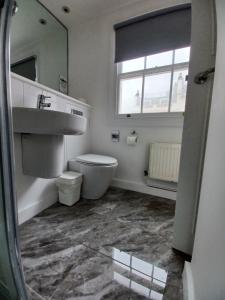 y baño con lavabo, aseo y espejo. en B&B Belgravia, en Londres
