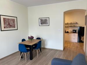 une salle à manger avec une table et des chaises bleues dans l'établissement Apartamenty przy Starym Mieście, à Częstochowa