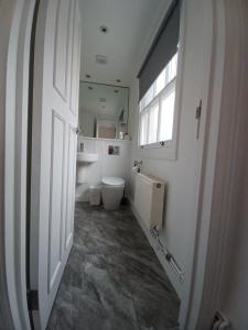 ein Bad mit einem WC, einem Fenster und einer Tür in der Unterkunft B&B Belgravia in London