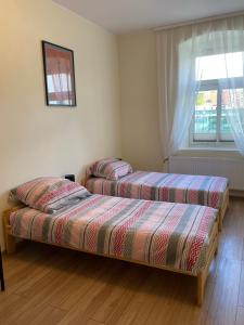 - 2 lits dans une chambre avec fenêtre dans l'établissement Apartamenty przy Starym Mieście, à Częstochowa