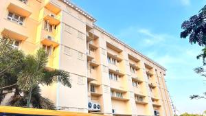 a tall building with palm trees in front of it at SET Residency in Kumbakonam