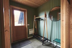 um quarto com paredes verdes e um espelho e um quarto com um espelho em Geysir Cabins - Golden Circle Cabin only 800m from Geysir em Selfoss