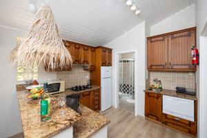 a kitchen with wooden cabinets and a counter top at Villa Irene in Mexilhoeira Grande