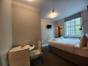 倫敦的住宿－貝爾格拉維亞酒店，酒店客房,配有床和一张带水果的桌子