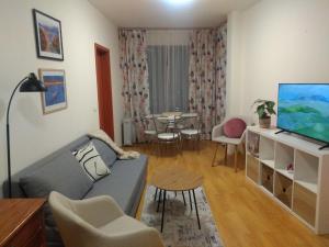 uma sala de estar com um sofá e uma televisão em TO FOUR+2 PREDELA 1 em Bansko