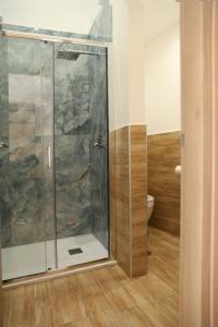 een badkamer met een douche en een glazen deur bij Mia Napoli in Napels