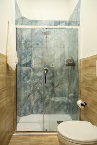 een douche met een glazen deur in de badkamer bij Mia Napoli in Napels
