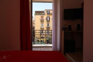 een slaapkamer met een raam met uitzicht op een gebouw bij Mia Napoli in Napels