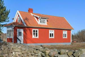Casa roja con ventanas blancas y pared de piedra. en Nice little red cottage in the countryside located outside Jamjo, en JÃ¤mjÃ¶