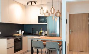 a kitchen with a table and four chairs in it at Luxury by Wave in Siófok