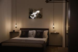 een slaapkamer met een bed met twee lampjes aan de muur bij Mia Napoli in Napels