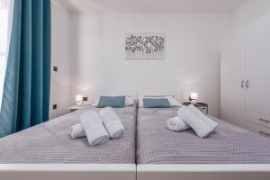 a large white bed with white pillows on it at Villa Cesarica ZadarVillas in Kakma +29 photos