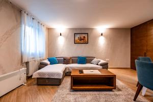 sala de estar con sofá y mesa en Apartmani Umac, en Nikšić