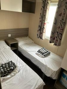 - 2 lits jumeaux dans une chambre avec fenêtre dans l'établissement Lido Beach Caravan, à Prestatyn