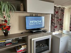 a flat screen tv sitting on top of a fireplace at Lido Beach Caravan in Prestatyn