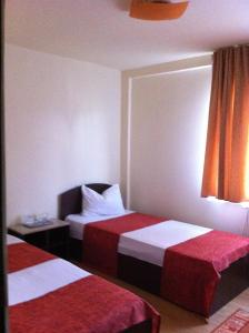 バイア・マーレにあるHostel Horaのベッド2台(赤と白のシーツ付)が備わる客室です。