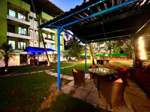 a patio with a table and chairs and a building at Hotel in GOA With Swimming Pool ,Managed By The Four Season - Close to Baga Beach in Goa