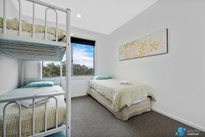 1 dormitorio con litera y ventana en Batemans Bay Apartment, en Batemans Bay