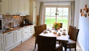 a kitchen with a wooden table with chairs and a tableasteryasteryasteryasteryastery at Insel Landhaus Seaside in Gager