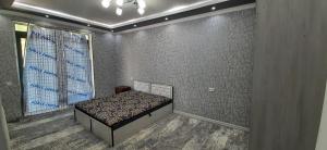 um quarto com uma cama num quarto com uma parede em Chilanzar-21, Tashkent em Tashkent