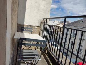 una mesa y sillas en el balcón de un edificio en Le charme Centre Parking wifi, en Châteauroux