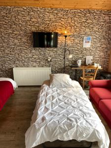 um quarto com uma cama e uma televisão na parede em Le petit moulin em Pouzauges