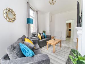 een woonkamer met 2 banken en een tafel bij 2 Bed House by AV Stays Short Lets Merseyside in Saint Helens