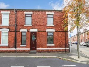 a red brick building with a door on a street at Cosy Home by AV Stays Short Lets Contractor Friendly Merseyside in Saint Helens