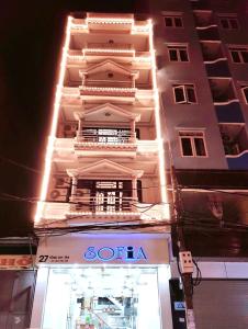 un edificio blanco alto con una tienda delante en Sofia Tống Duy Tân, en Sầm Sơn