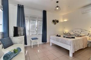 1 dormitorio con 1 cama, TV y sofá en Ty Paradis Magnifique Lodge pour un couple en Sainte-Anne